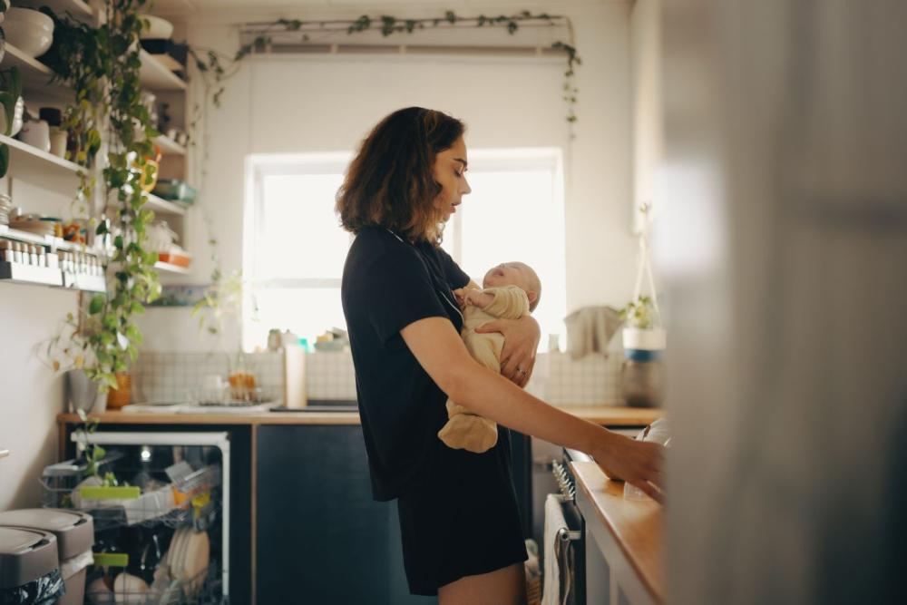 Postpartum Hormones Exhausted mom holding baby
